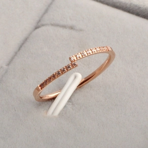 Close-up of rose gold ring with inlaid diamonds in a grey velvet jewelry box