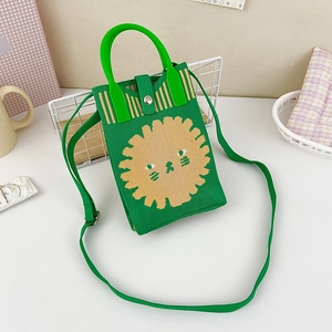 Detail of green knit crossbody bag featuring cartoon lion motif and knit texture
