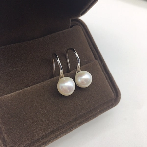 Elegant freshwater pearl drop earrings with silver hooks displayed in a brown jewelry box