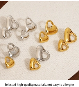 Orecchini a cuore scavato lucido in oro, argento e bicolore su sfondo di lino