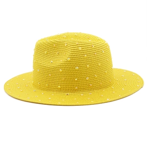 Close-up of yellow straw fedora hat featuring sparkling gold rhinestone embellishments