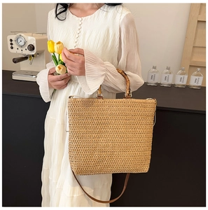 French straw woven tote with bamboo handles shown in a lifestyle summer setting