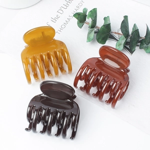 Glossy solid color hair claw clips in yellow and brown shades for elegant hairstyling