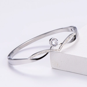 Detail of silver titanium bangle with V-shaped design and brilliant round zircon inlay