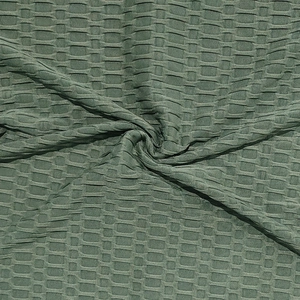 Détail macro de la texture gaufrée respirante vert sauge sur le t-shirt de sport pour homme