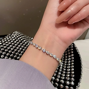 Detailed view of silver tone bracelet featuring pear-cut cubic zirconia on a wrist