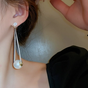 Elegant long chain tassel earrings with pearls and zircon on a model for a modern look