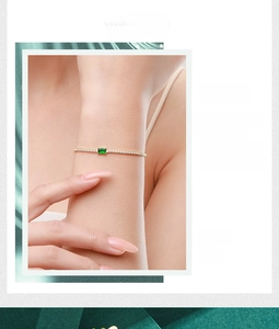 Detail of s925 silver gold bracelet featuring green emerald-cut stone and pavé diamonds