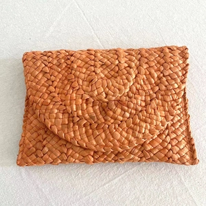 Handmade orange woven straw clutch bag in envelope style for summer beach vacations
