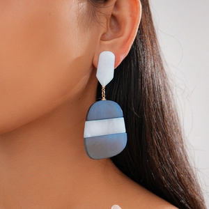 Side view of model wearing large geometric blue and white acetate oval drop earrings