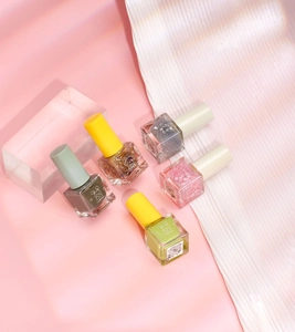 Detailed set of five water-based nail polish bottles in various colors on pink background