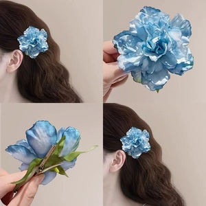 Detail view of large blue gradient silk flower hair clip with metal duckbill back