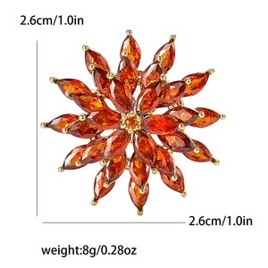 Detailed view of orange crystal flower brooch with gold base, 2.6cm size and 8g weight specs