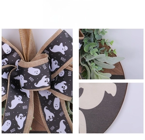 Detail of Halloween wooden door sign featuring BOO ribbon, linen bow and green leaves