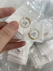 Détail des bagues perlées dorées taille 8 présentées dans leur emballage individuel