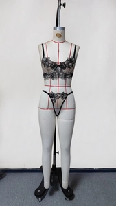 Detail of black floral embroidery on sheer mesh lingerie set with lace and straps