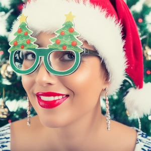 Gros plan sur des lunettes de fête en forme de sapin de Noël vert avec boules rouges