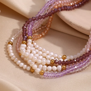 Macro shot of freshwater pearls and multi-colored crystal beads on a layered necklace