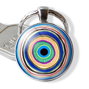 Macro shot of silver metal Evil Eye keychain pendant with colorful glass texture insert