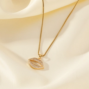 Gold-plated lip pendant necklace with micro-paved cubic zirconia on beige silk background