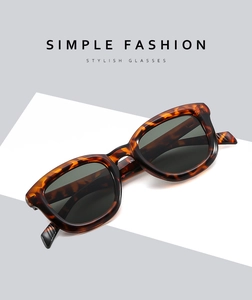 Detail of tortoise shell square frame sunglasses with dark lenses on a white pedestal