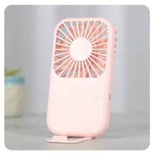 Pink portable mini USB fan on desk showing foldable stand and multi-blade design