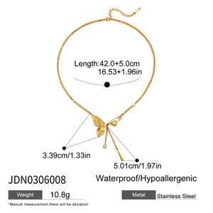 Macro shot of gold stainless steel necklace with butterfly and heart pin zircon tassels