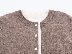 Detail of round neckline and pearly buttons on brown contrast knit cardigan sweater