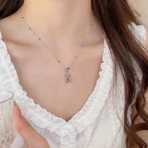 Close-up of silver necklace with colorful beads and 3D bear pendant on model neck