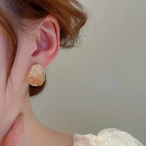 Close-up of elegant French vintage oval gold earrings with champagne crystal inserts