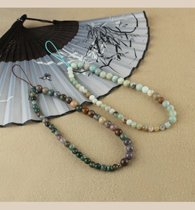 Detail of Chinese style beaded phone charms with turquoise and agate on a folding fan