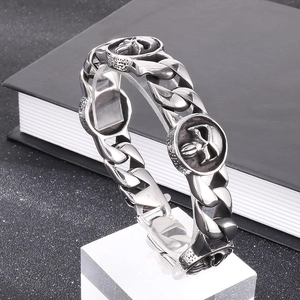 Macro detail of 316L stainless steel bracelet with 22mm skull charm and Cuban links