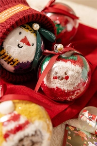 Detailed view of plush Christmas socks in a clear gift ball with festive ribbons