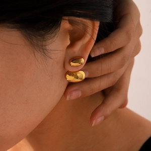Orecchini a lobo minimalisti a forma di fagiolo placcati in oro 18k indossati da modella