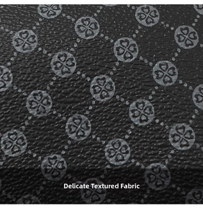 Macro de la texture du cuir grainé anthracite avec motif trèfle gris sur le sac