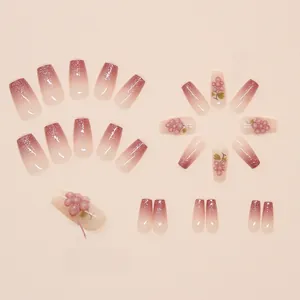 Detailed view of 3D grape charms and pink glitter gradient on trapezoid fake nails