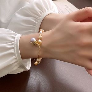 Gros plan d'un bracelet en perles avec breloque chat en zircon et détails dorés élégants