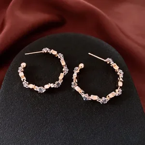 Luxurious gold C-shaped hoop earrings with sparkling cubic zirconia stones