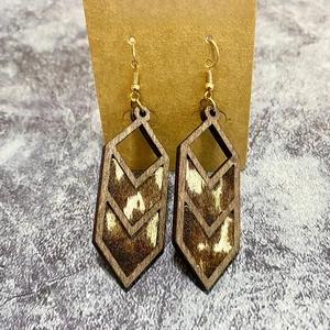 Detail of western geometric leopard print earrings with wooden frames and metal hooks