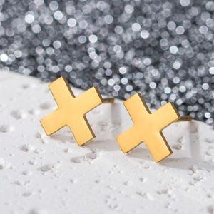 Macro shot of 18K gold plated stainless steel geometric X-shaped earrings on stone