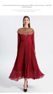 Detail of dark red pleated chiffon dress featuring gold beaded neck and sleeve accents