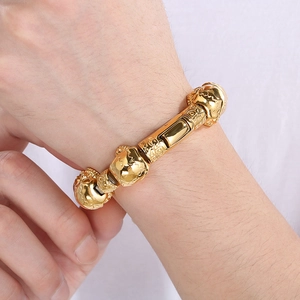 Macro shot of punk style stainless steel bracelet with golden skull and beast head beads