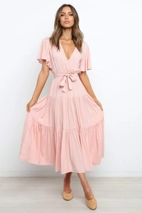 Detalle de vestido rosa con cuello en V, mangas de volante y lazo ajustable en cintura