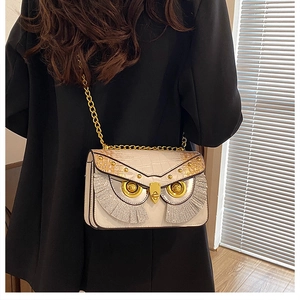Détail du mini sac chouette avec texture crocodile et bandoulière en chaîne dorée élégante