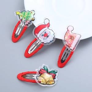 Set of 4 Christmas quicksand hair clips with Santa, tree, and bell patterns on grey background