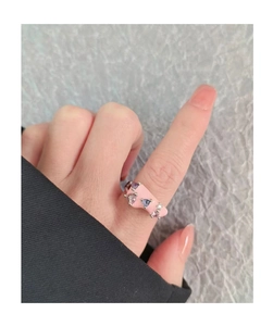 Close-up of pink macaron enamel open ring with colorful zircon stones on finger