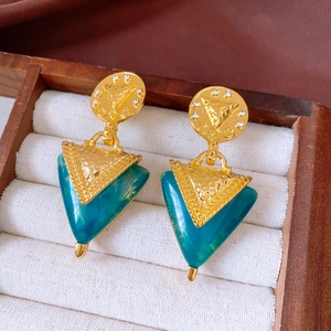 Detailansicht der Vintage Gold-Dreiecksohrringe mit blauem Harz in einer weißen Samt-Box