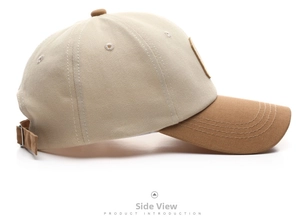 Detailed side view of two-tone cotton baseball cap with adjustable strap and contrast brim