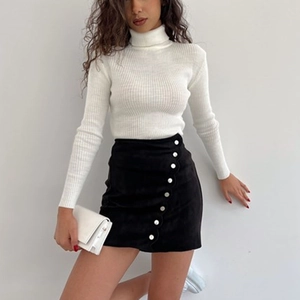 Detail showing the wavy placket and white buttons on a black faux suede mini skirt
