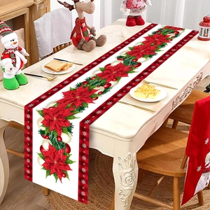 Detail of Christmas table runner with red poinsettia flowers and black-red plaid edges